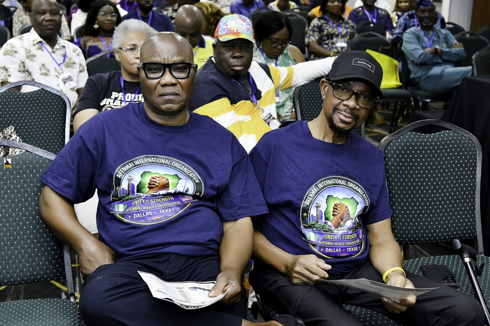 Two men in convention T-shirts seated together