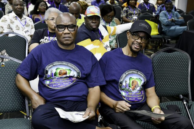 Two men in convention T-shirts seated together