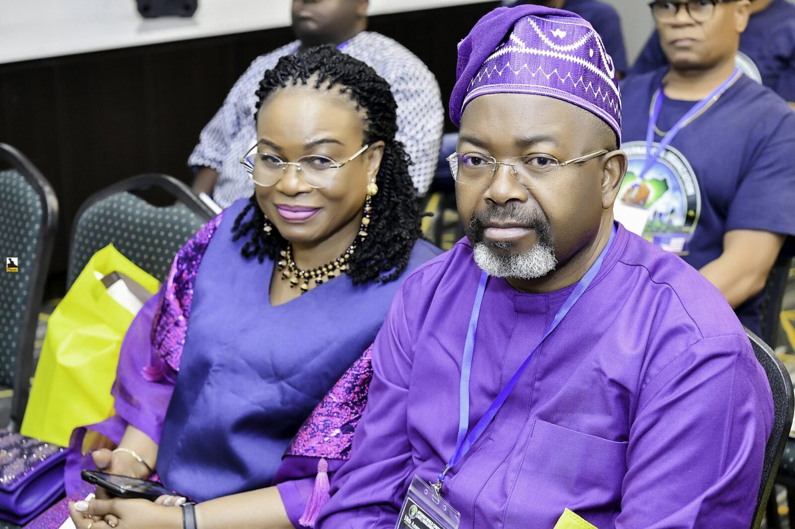 Two attendees in blue clothing seated side by side