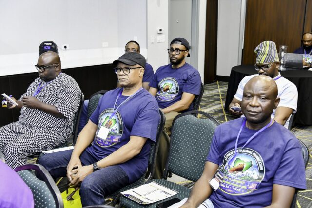 Men in convention T-shirts seated in a row