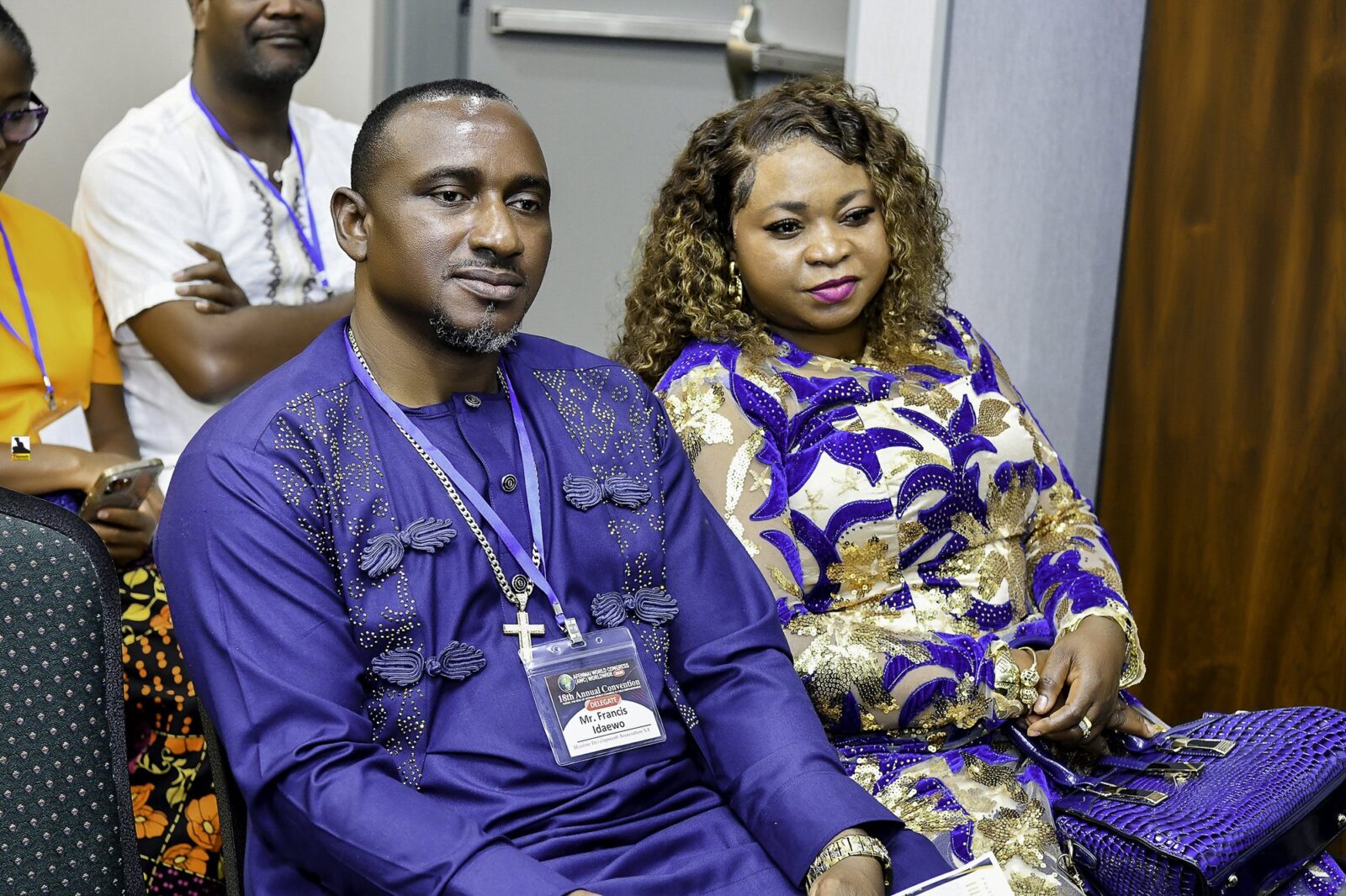 Two attendees in blue clothing seated together