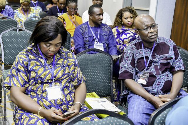 Two attendees in patterned clothing reading together