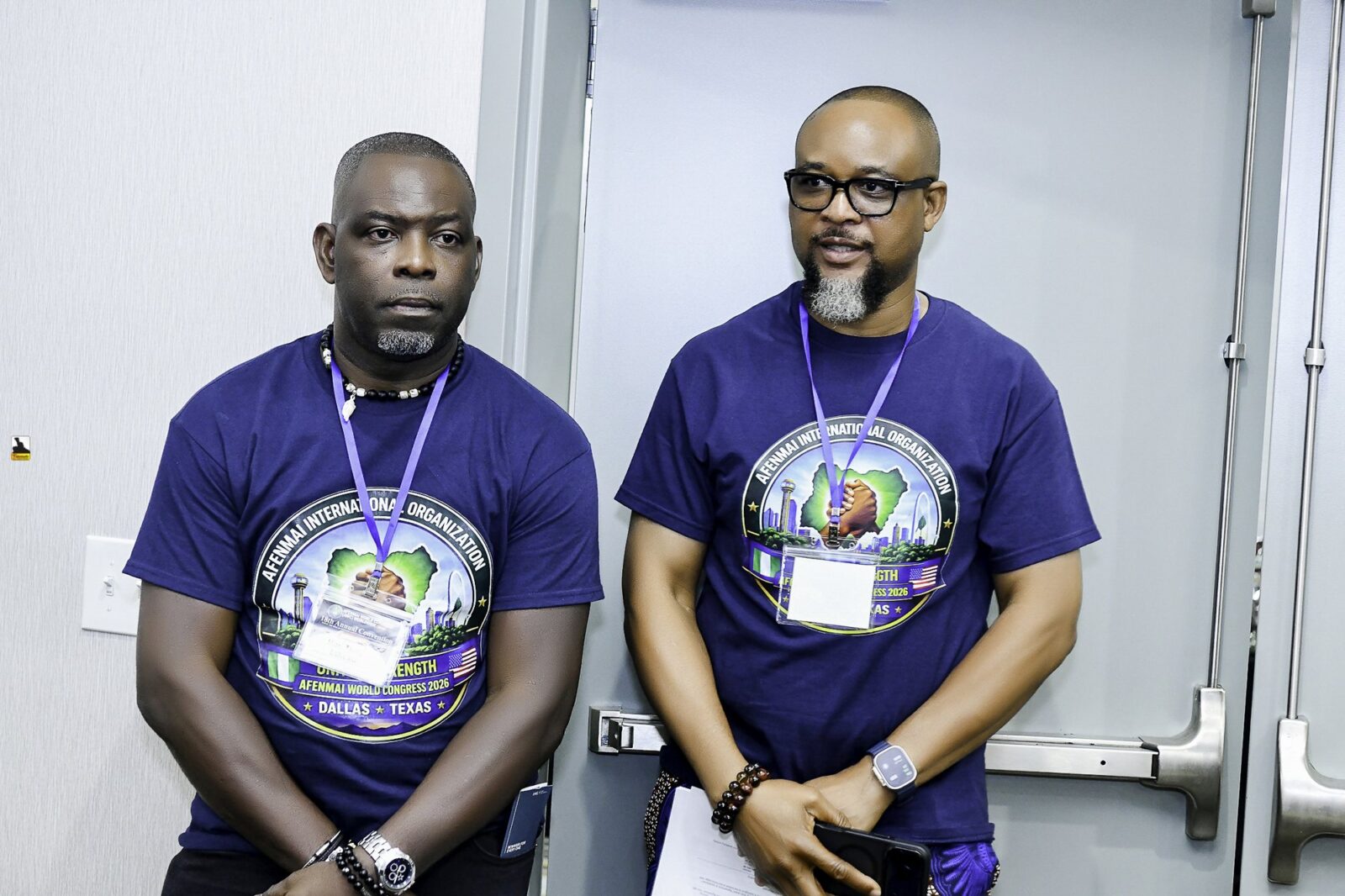Men in convention T-shirts at the front of the room