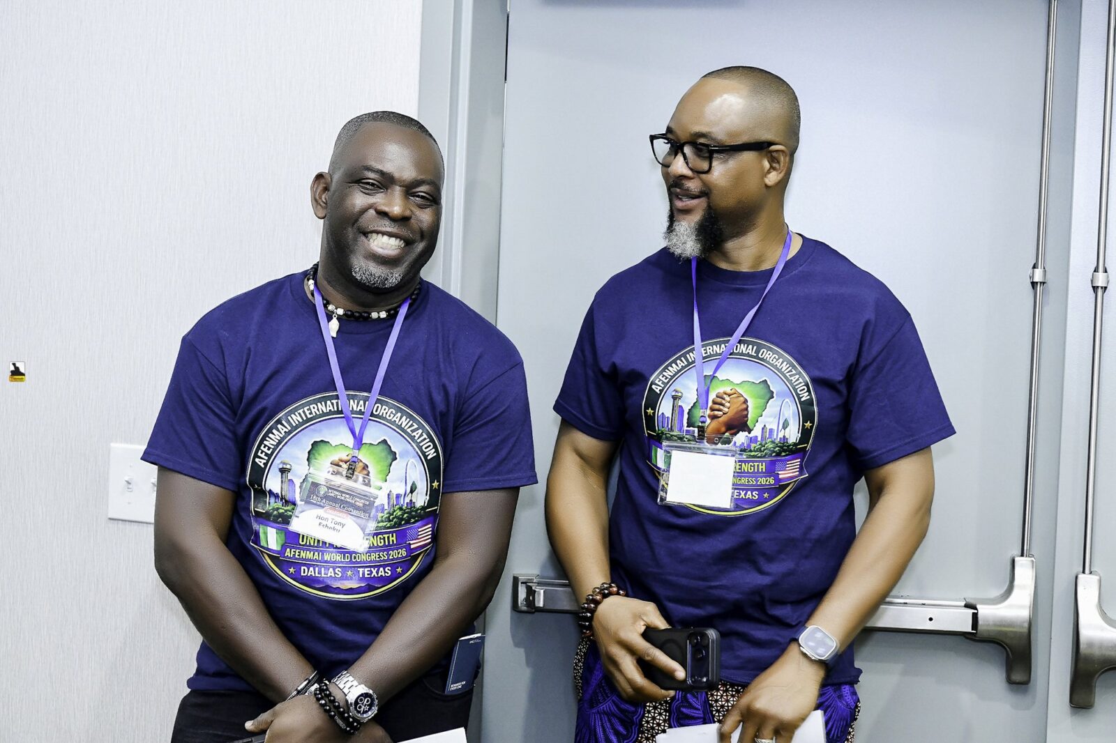 Men in convention T-shirts at the front of the room