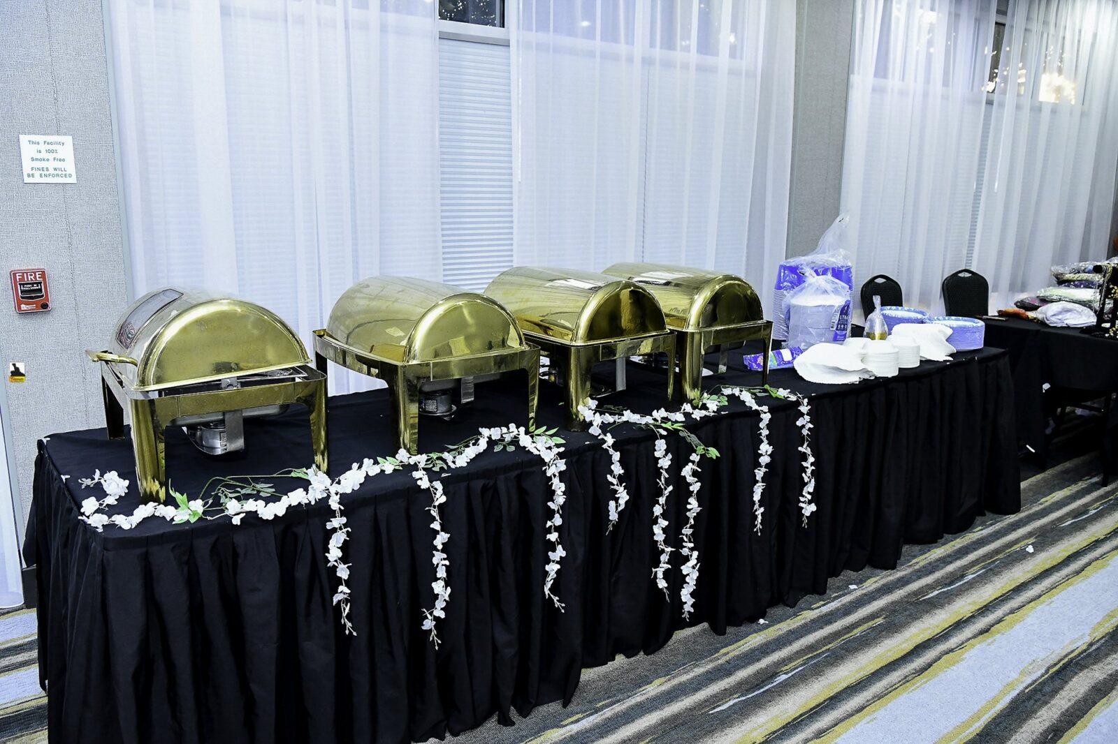 Covered serving trays arranged on a buffet table