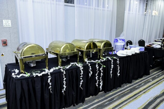 Covered serving trays arranged on a buffet table