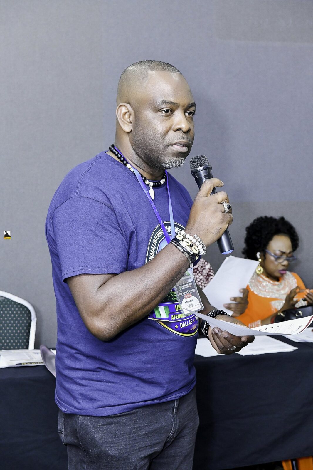 Man in a convention T-shirt holding a microphone