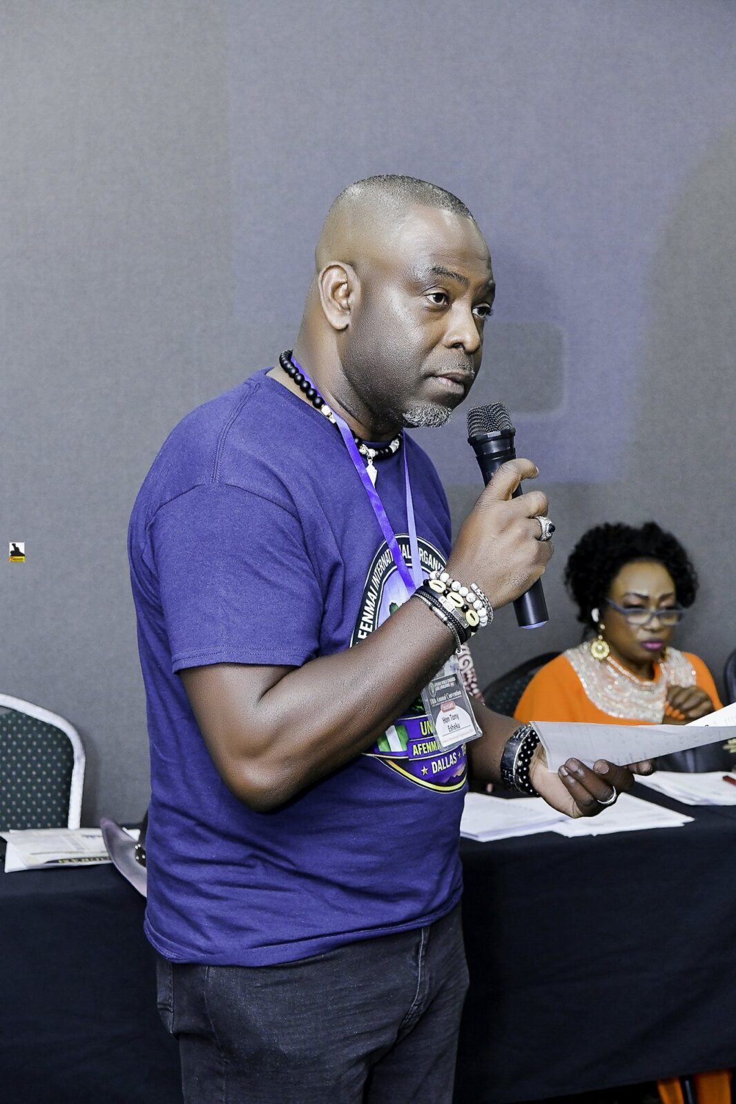 Man in a convention T-shirt holding a microphone