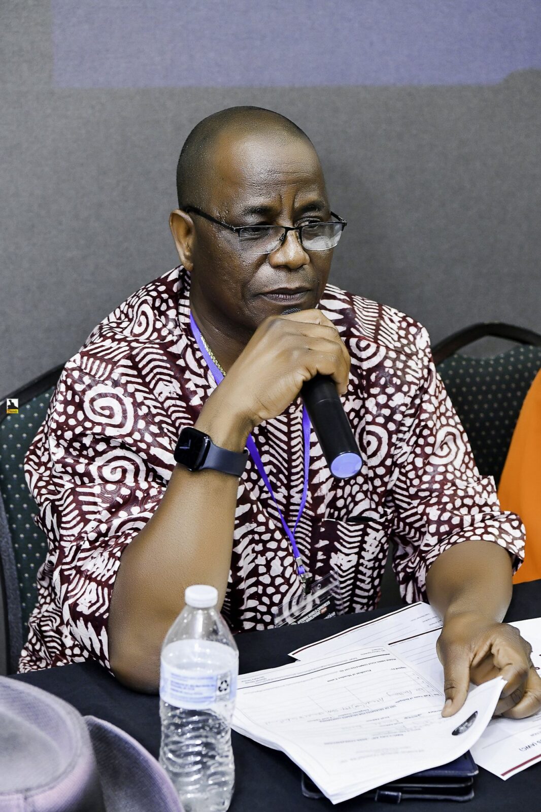 Man in a patterned shirt resting his chin on his hand