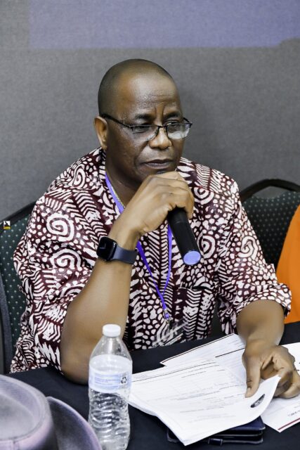 Man in a patterned shirt resting his chin on his hand
