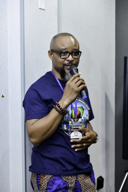 Man in a convention T-shirt holding a microphone