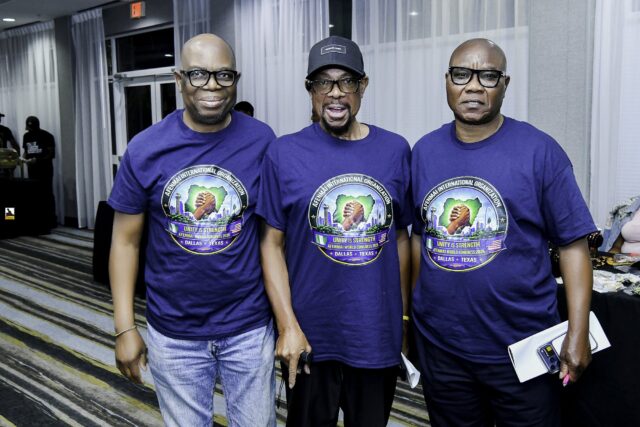 Three men in blue convention T-shirts standing together