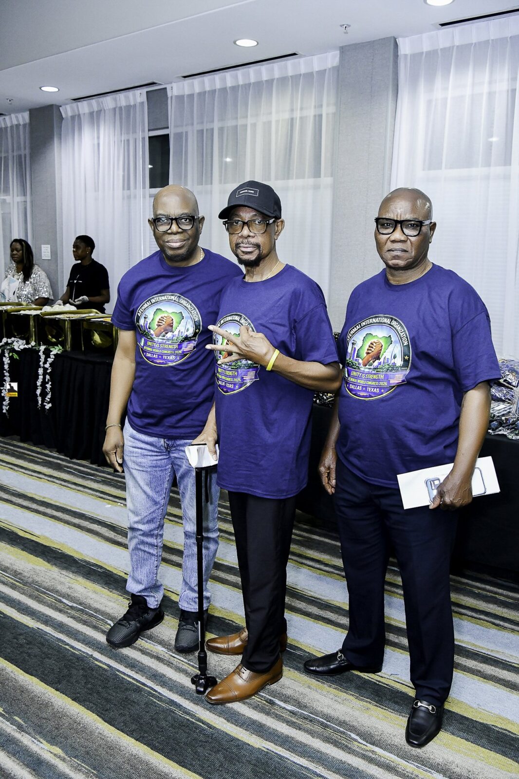 Three men in blue convention T-shirts standing together