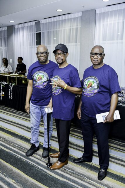 Three men in blue convention T-shirts standing together
