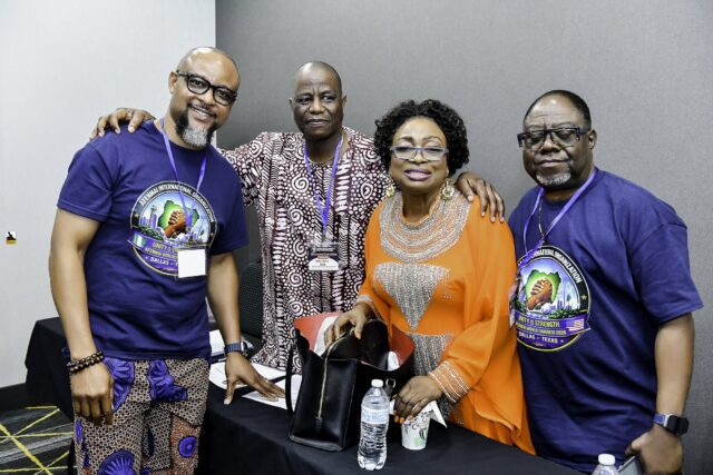 Three men and a woman in orange standing together