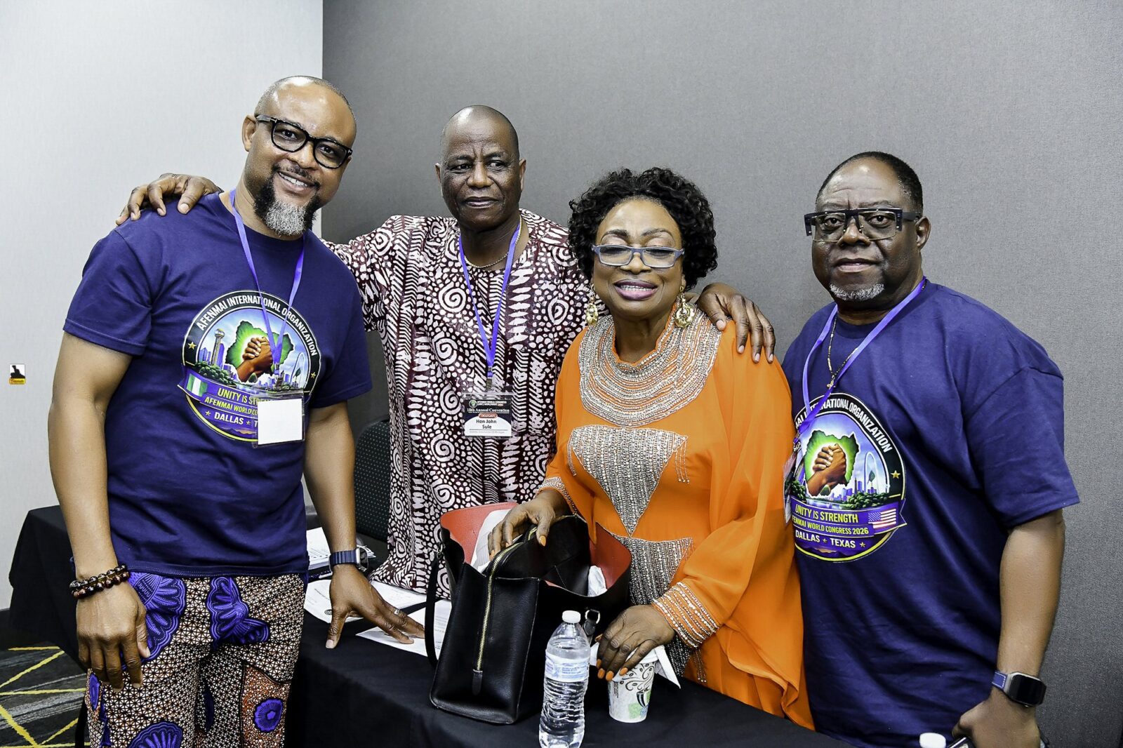 Three men and a woman in orange standing together