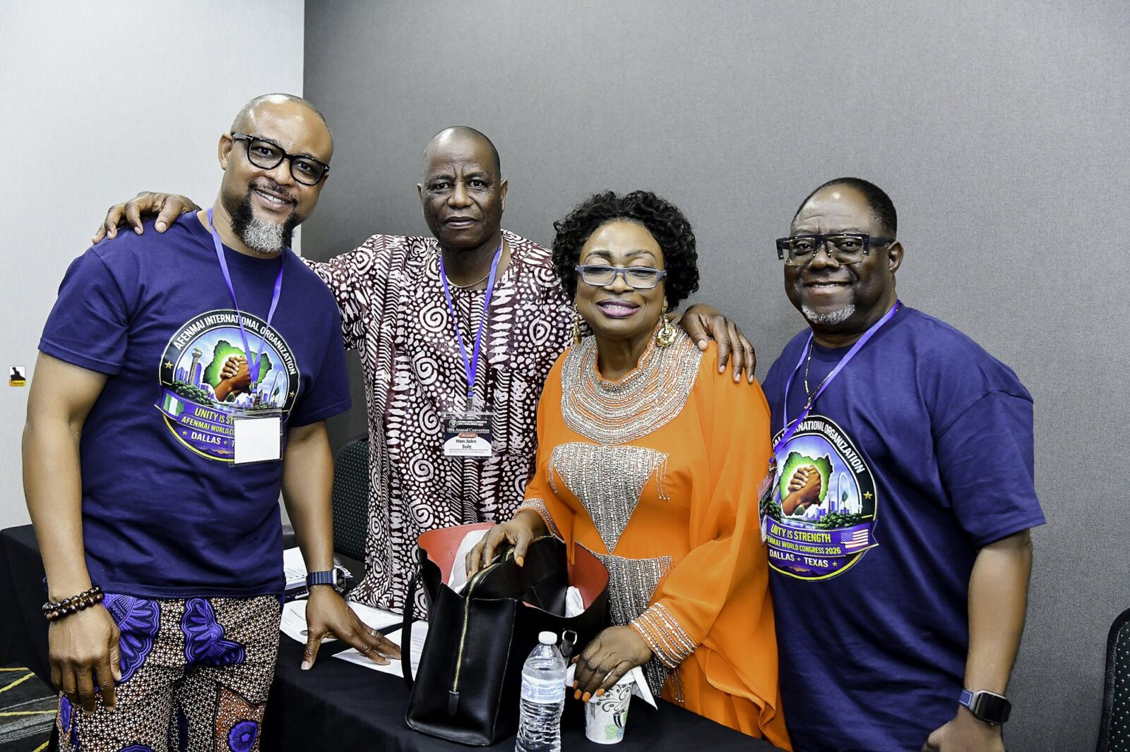 Three men and a woman in orange standing together