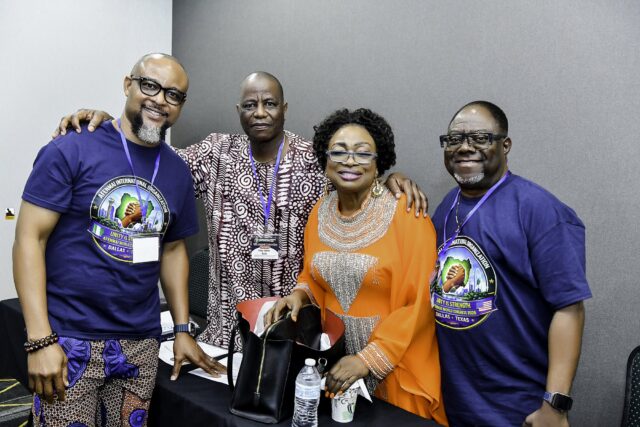 Three men and a woman in orange standing together