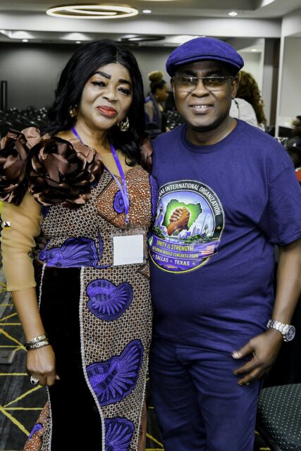 Woman in patterned blue clothing beside a man wearing a cap