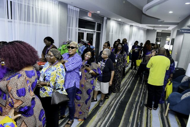 Attendees lined up beside food serving tables