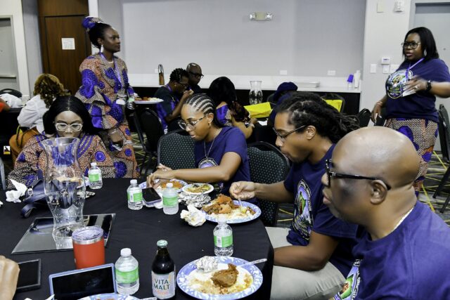 Convention attendees eating and talking around a table