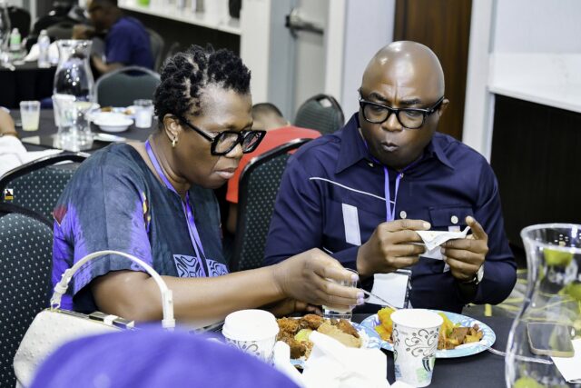 Convention attendees eating and talking around a table