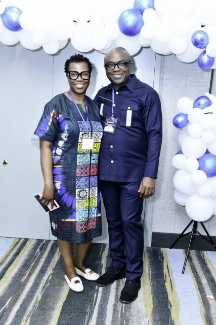 Man in a suit and woman in a colorful patterned outfit standing together