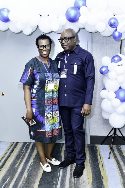 Man in a suit and woman in a colorful patterned outfit standing together