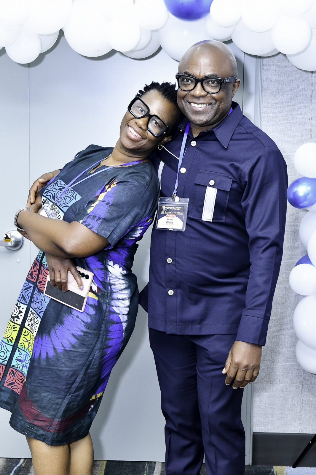 Man in a suit and woman in a colorful patterned outfit standing together