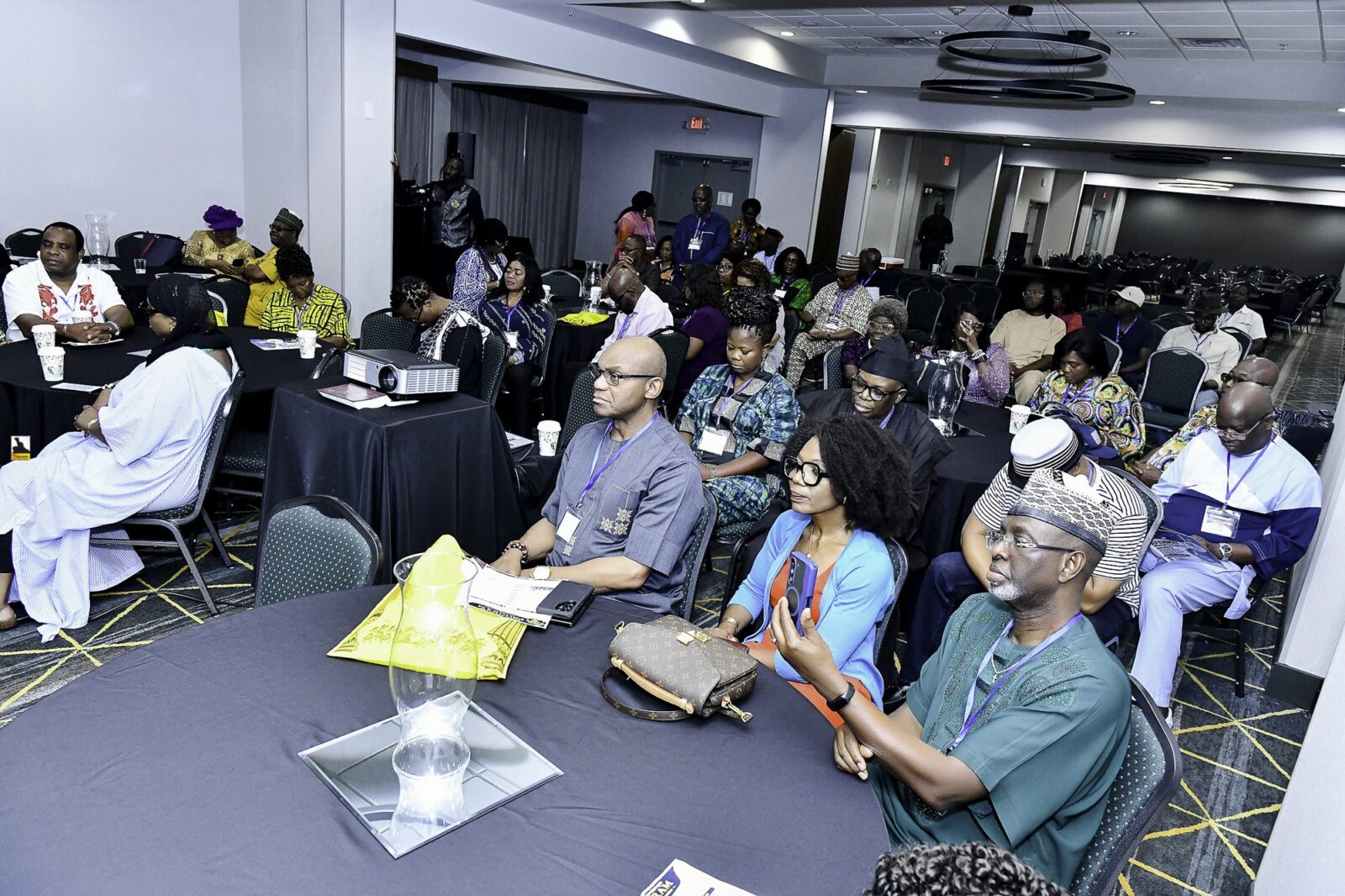 Attendees in colorful clothing seated across the room