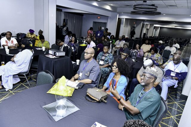 Attendees in colorful clothing seated across the room