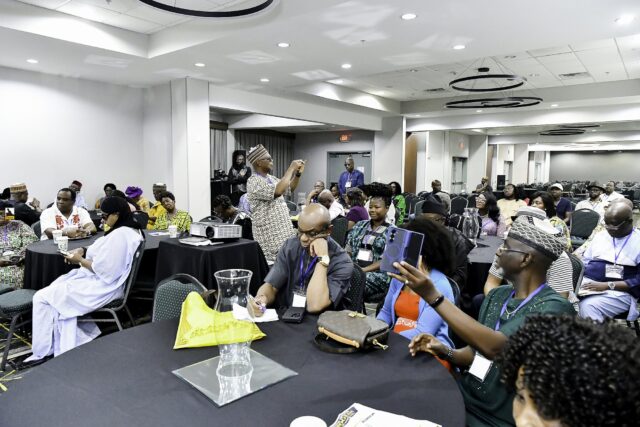Attendees in colorful clothing seated across the room