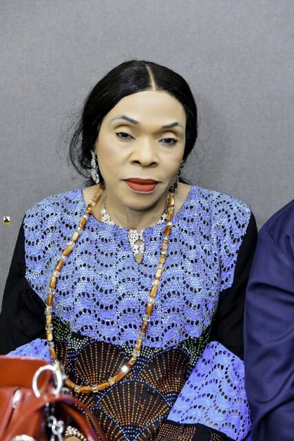 Woman in a blue patterned outfit seated in the room
