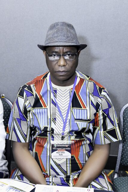 Man in a multicolored patterned cap seated in the room