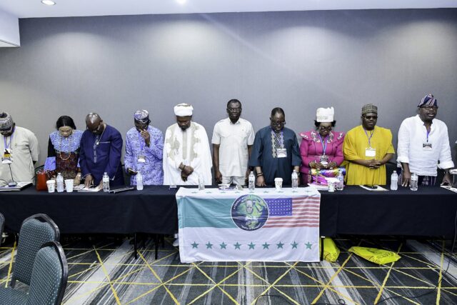 Attendees standing behind the front table with heads lowered