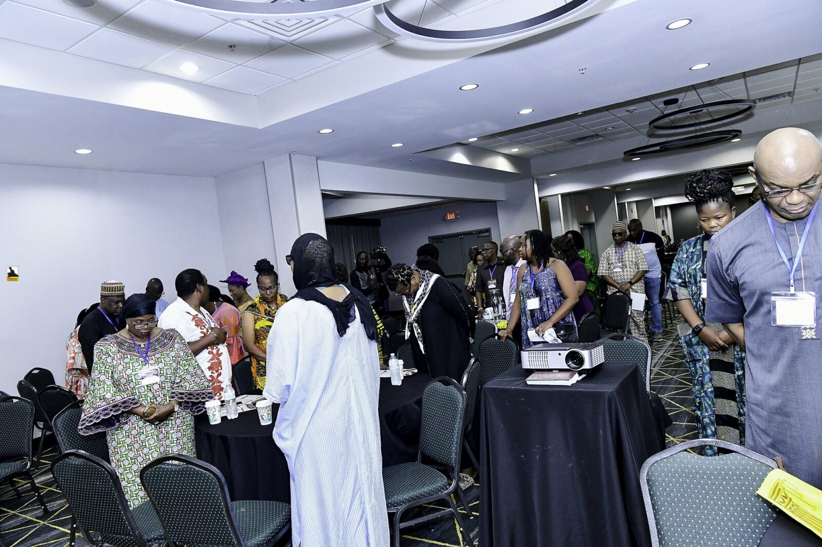 Attendees standing beside their chairs with heads lowered