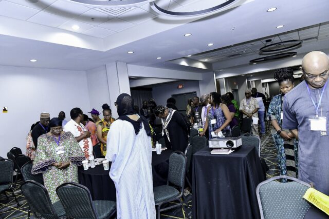Attendees standing beside their chairs with heads lowered