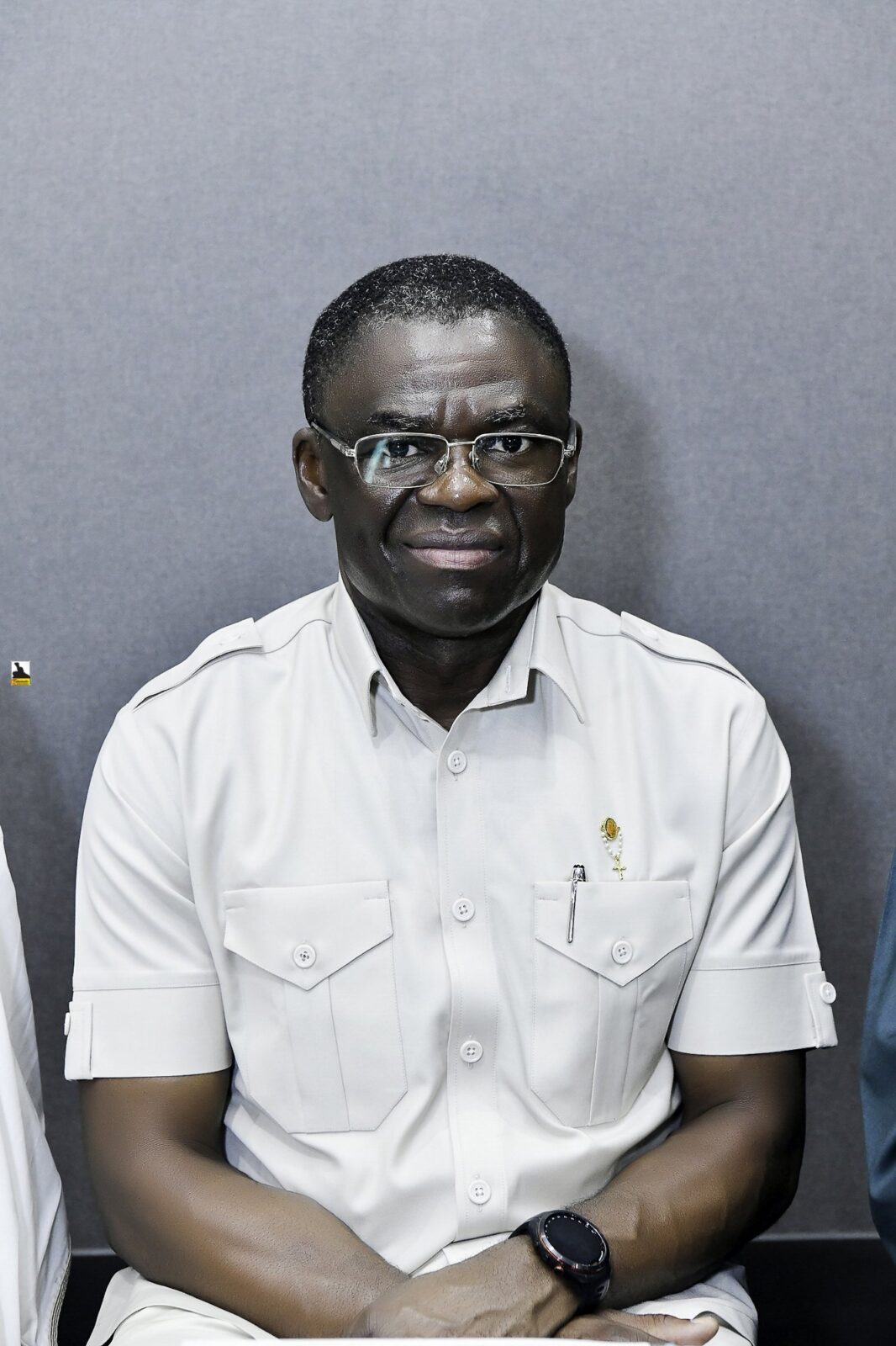 Smiling man in a white shirt seated in the room