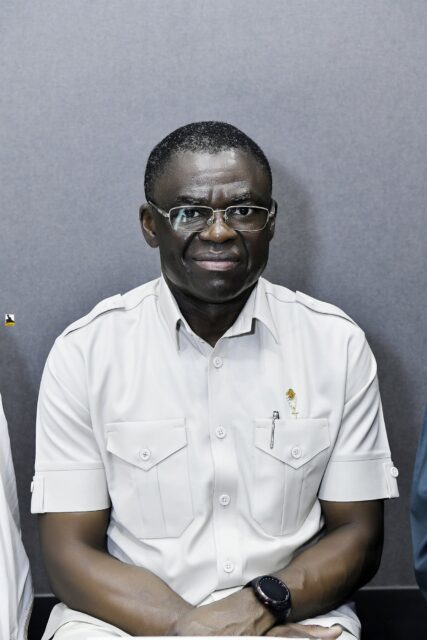 Smiling man in a white shirt seated in the room