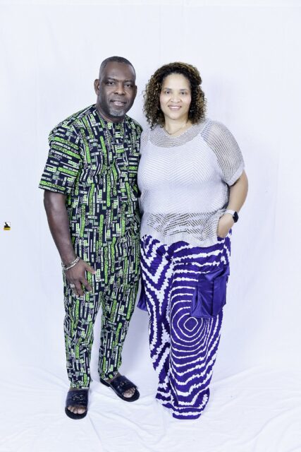Man in green patterned clothing and woman in a light top posing together