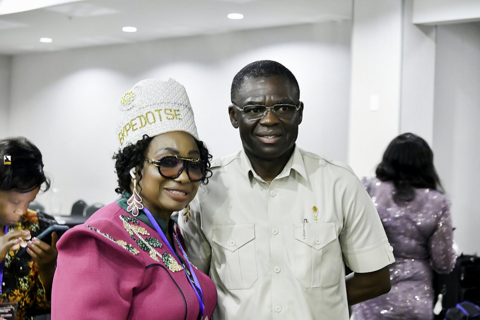Woman in pink clothing and a white hat beside a smiling man in white