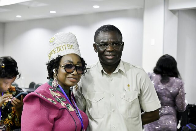 Woman in pink clothing and a white hat beside a smiling man in white