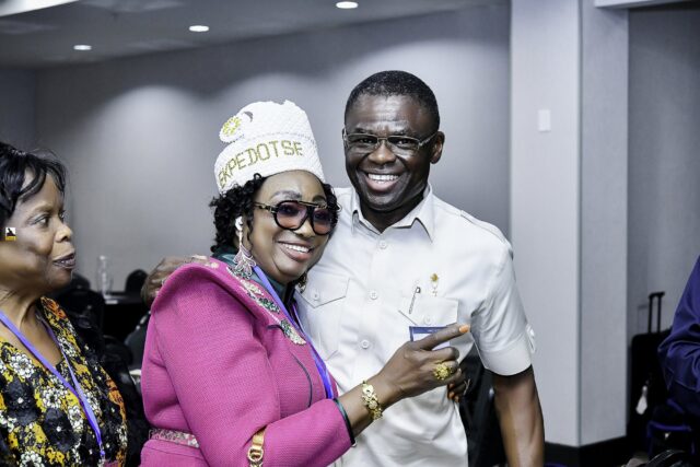 Woman in pink clothing and a white hat beside a smiling man in white