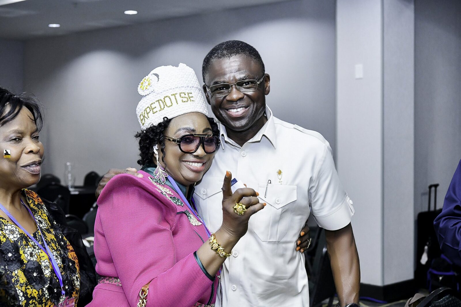 Woman in pink clothing and a white hat beside a smiling man in white