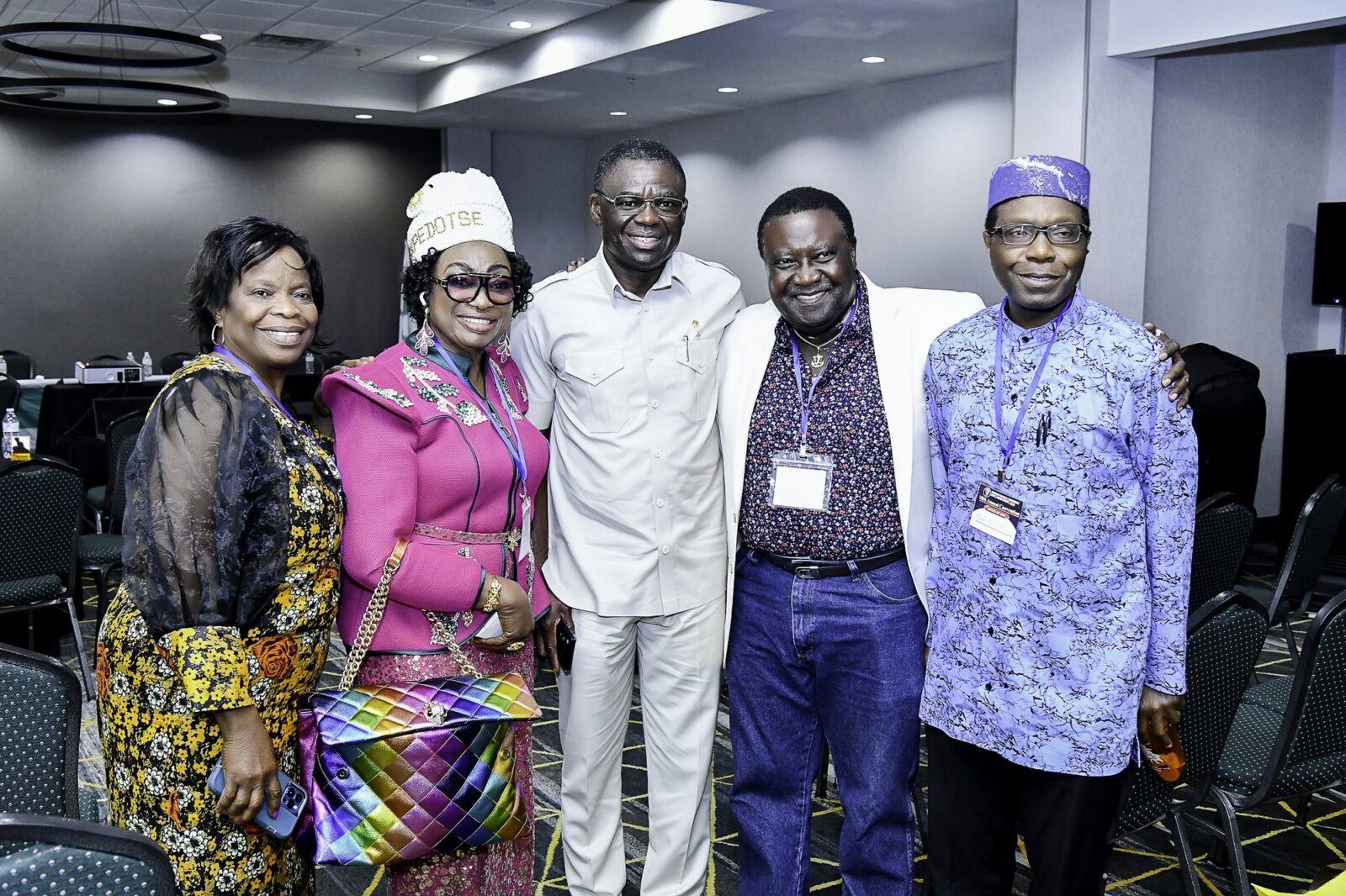 Five attendees posing together in the convention room