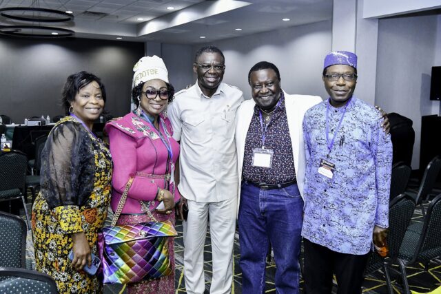 Five attendees posing together in the convention room