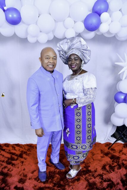 Man in lavender and woman in white and blue standing together
