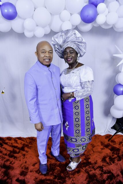 Man in lavender and woman in white and blue standing together