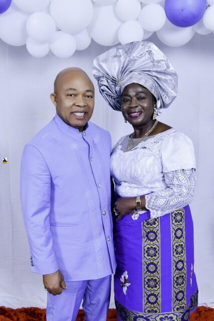 Man in lavender and woman in white and blue standing together