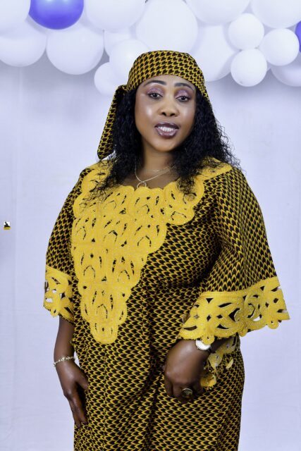 Woman in a brown and yellow outfit posing by the balloons